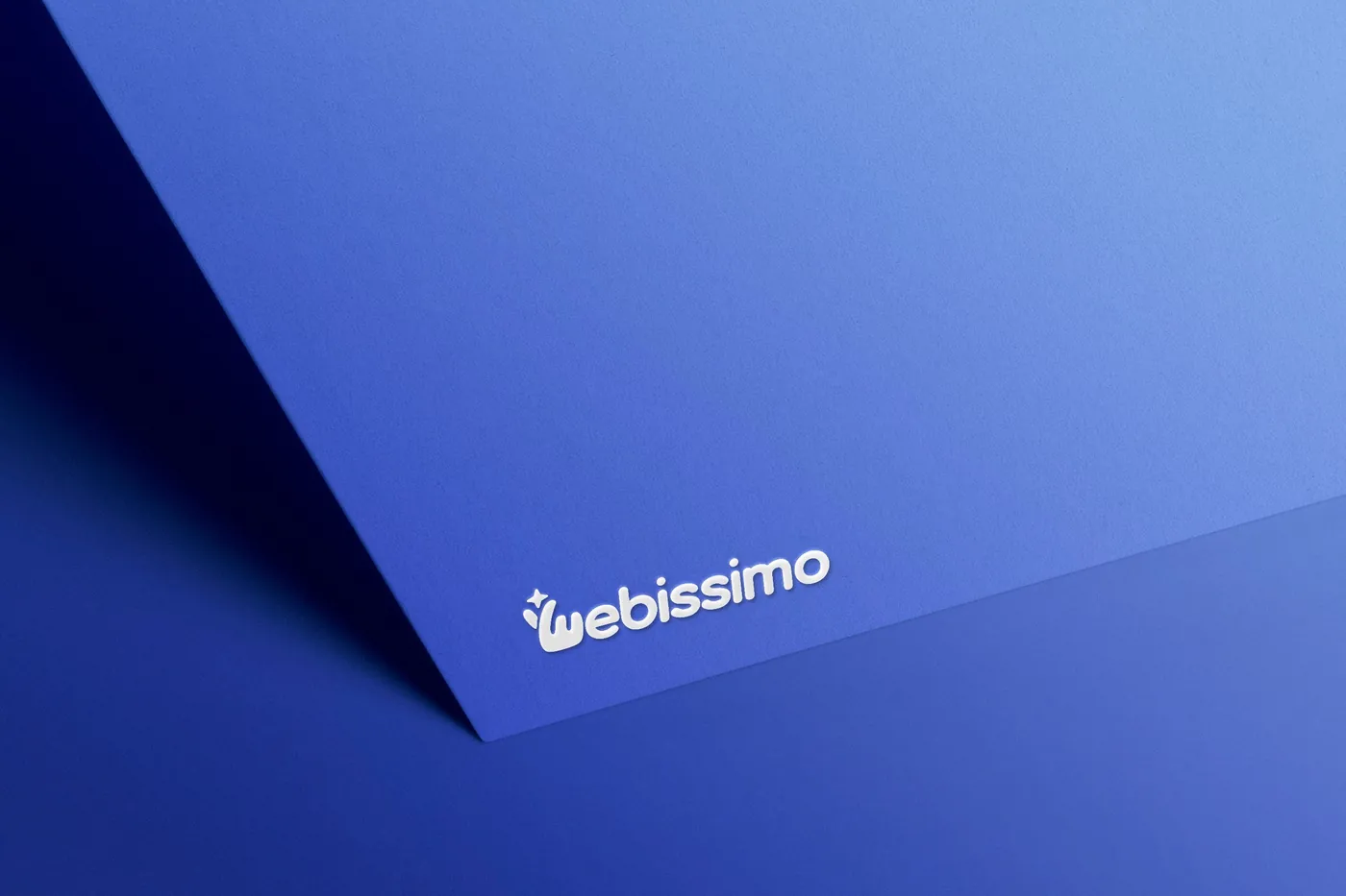 Bílé logo Webissimo vyražené do modrého papíru